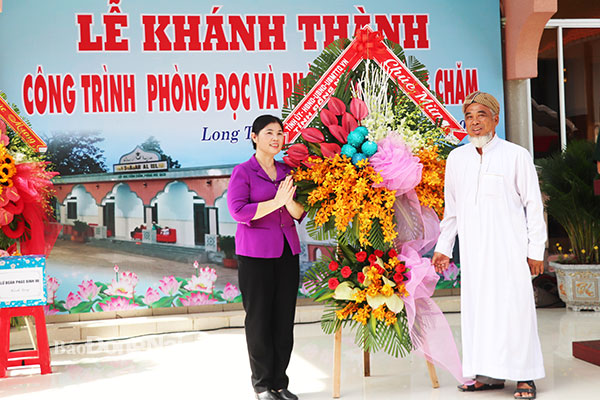 Phó trưởng Ban Dân vận Tỉnh ủy Phạm Thị Kim Chung tặng lẵng hoa chúc mừng của Tỉnh ủy - HĐND - UBND - Ủy ban MTTQ Việt Nam tỉnh nhân lễ khánh thành công trình phòng đọc và học tiếng Chăm ở xã Bình Sơn. Ảnh: H.Yến