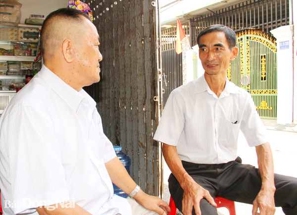 Cựu chiến binh Hoàng Văn Cổn (phải) trao đổi cùng người dân. Ảnh: S.Thao