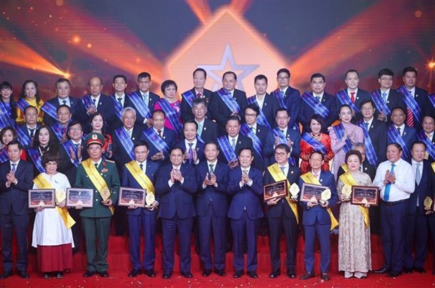 PM Pham Minh Chinh (5th from left, first row) and outstanding businesspeople pose for a group photo.