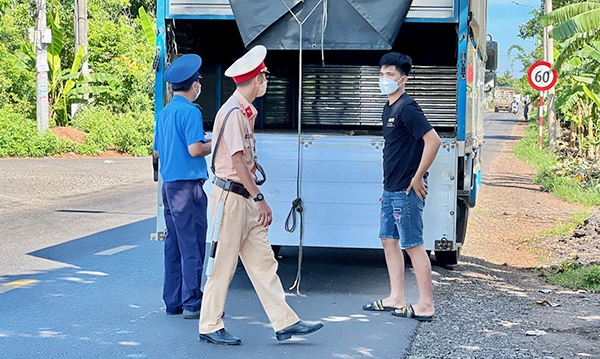 Lực lượng Cảnh sát giao thông và Thanh tra giao thông phối hợp kiểm tra việc sắp xếp hàng hóa của các phương tiện trên đường tỉnh 762 (H.Thống Nhất)