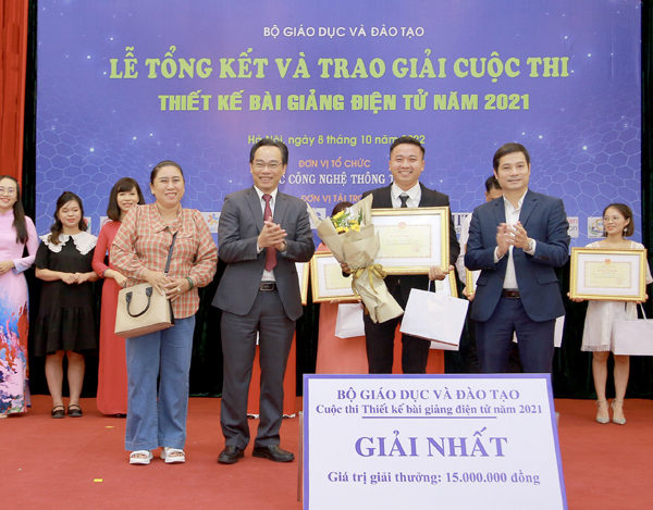 Thứ trưởng Bộ GD-ĐT Hoàng Minh Sơn (thứ hai từ trái sang) trao giải nhất cuộc thi thiết kế bài giảng điện tử cho thầy giáo Nguyễn Thành Hiệp. Ảnh: HT