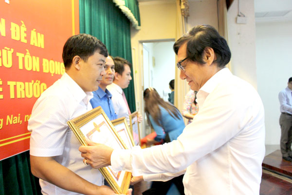 Phó chủ tịch UBND tỉnh Nguyễn Sơn Hùng trao bằng khen cho các tập thể, cá nhân tại hội nghị tổng kết thực hiện đề án Chỉnh lý tài liệu lưu trữ tồn đọng từ năm 2015 trở về trước. Ảnh: T.Lâm