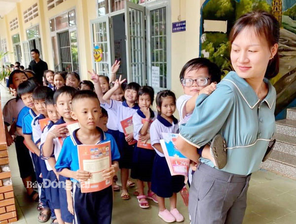 Em Nguyễn Thiên Ân cùng cô giáo Đoàn Thị Tuyết và các bạn trong lớp xếp hàng xuống sân trường tham gia các hoạt động ngoại khóa. Ảnh: M.Dũng