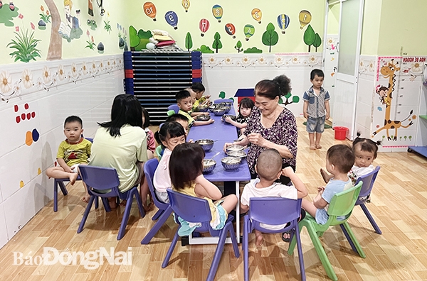 Người trông trẻ Nhóm trẻ tư thục độc lập Ban Mai (P.Long Bình, TP.Biên Hòa) phục vụ trẻ ăn bữa xế trước khi được cha mẹ đến đón