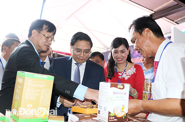 Thủ tướng Chính phủ Phạm Minh Chính (giữa) tham quan gian hàng trưng bày các sản phẩm tiêu biểu của tỉnh Đồng Nai tại hội nghị