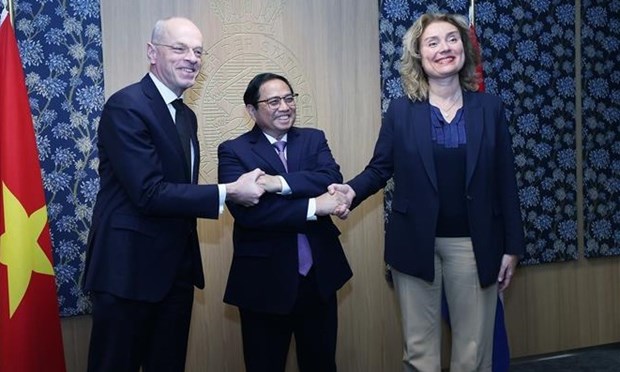 Prime Minister Pham Minh Chinh (C) shakes hands with President of the Senate and Speaker of the House of Representatives of the Netherlands Jan Anthonie Bruijn and Vera Bergkamp 