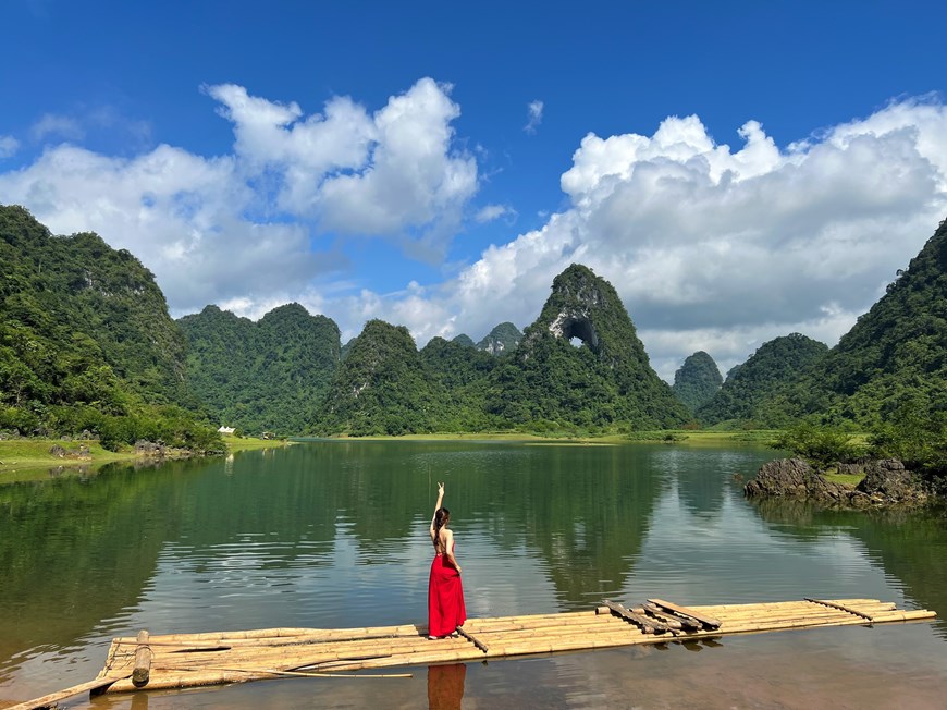 A woman poses for a photo with the mountain in the background. 