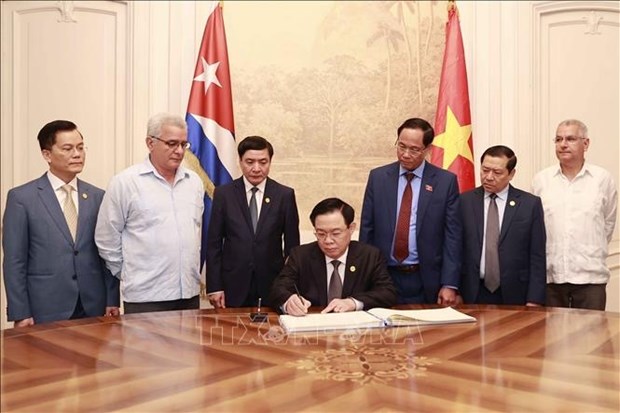NA Chairman Vuong Dinh Hue writes in the centre's guest book. 