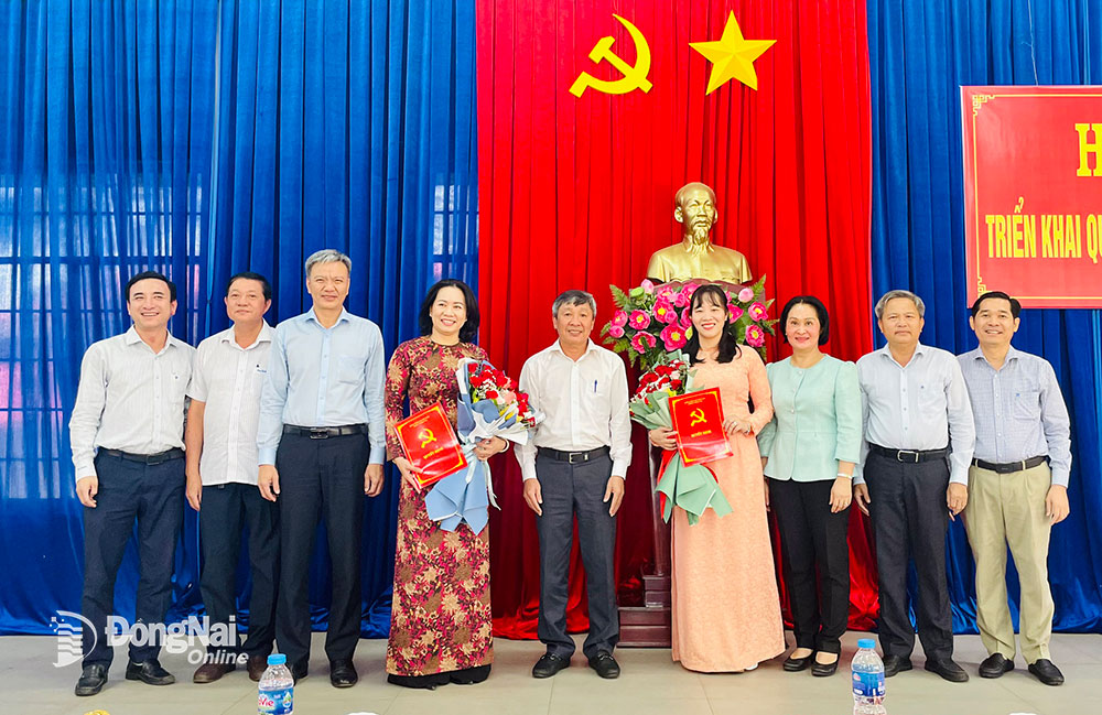 Phó bí thư thường trực Tỉnh ủy Hồ Thanh Sơn trao quyết định, lãnh đạo UBND huyện tặng hoa cho các cán bộ được điều động, bổ nhiệm