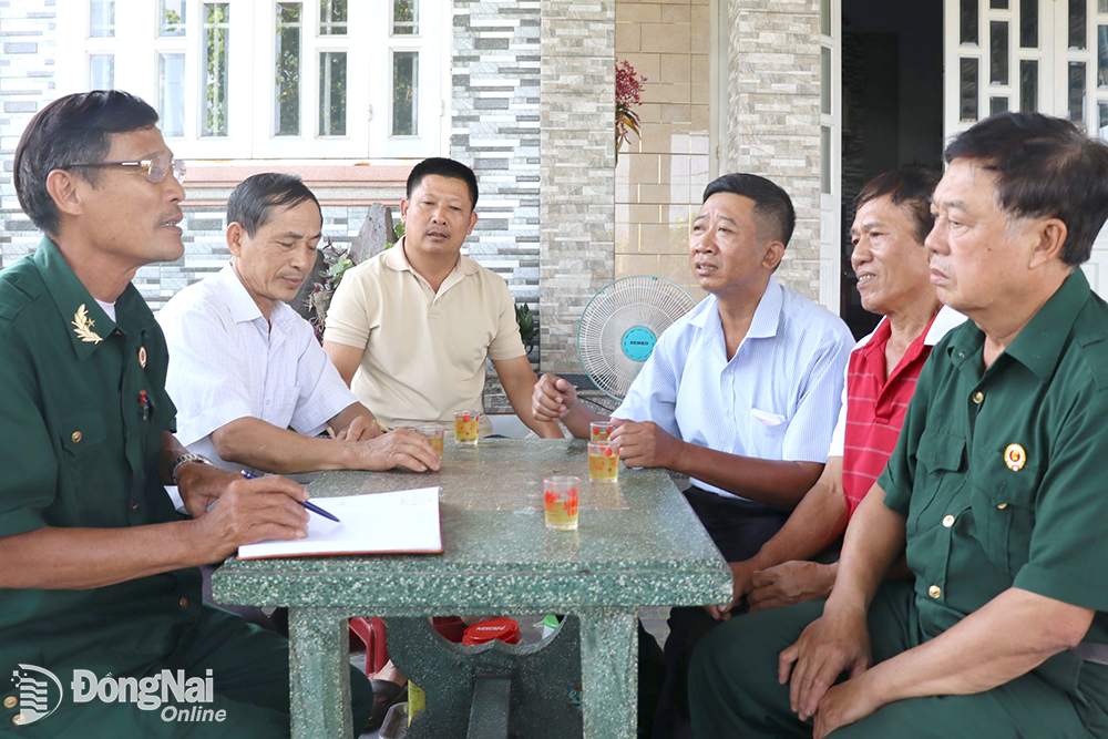 Cựu chiến binh, đảng viên Trần Đức Hoa (bìa trái) họp bàn xây dựng đường nông thôn mới