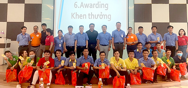 Chị Đoàn Thị Kim Loan (thứ 4 từ trái qua) cùng Ban giám đốc và các tổ chức chính trị - xã hội trong công ty  tặng quà cho người lao động dịp Tết 2023