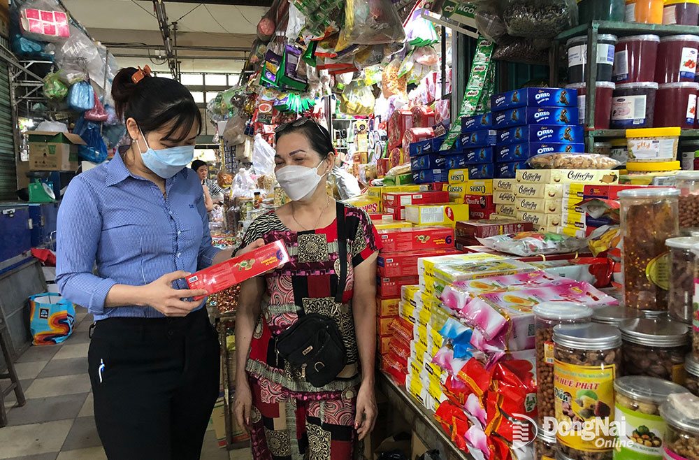 Người tiêu dùng chọn mua các loại bánh kẹo của các doanh nghiệp Việt tại chợ Long Thành (H.Long Thành)