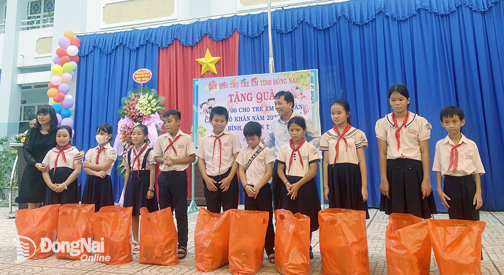 Ông Hoàng Văn Long, Giám đốc Quỹ Bảo trợ trẻ em tỉnh tặng quà cho trẻ em ở xã Phú Bình, H.Tân Phú (Ảnh: Quỹ BTTE tỉnh cung cấp)