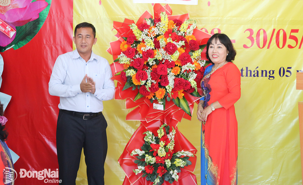 Đại diện lãnh đạo địa phương xã Phú Thạnh (bìa trái), nơi quỹ đứng chân tặng hoa chúc mừng 15 năm thành lập quỹ