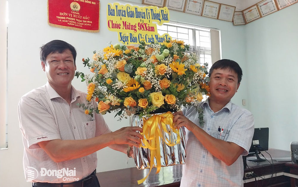 Đồng chí Lê Huy Thiêm (bên trái) tặng hoa chúc mừng Ngày Báo chí cách mạng Việt Nam