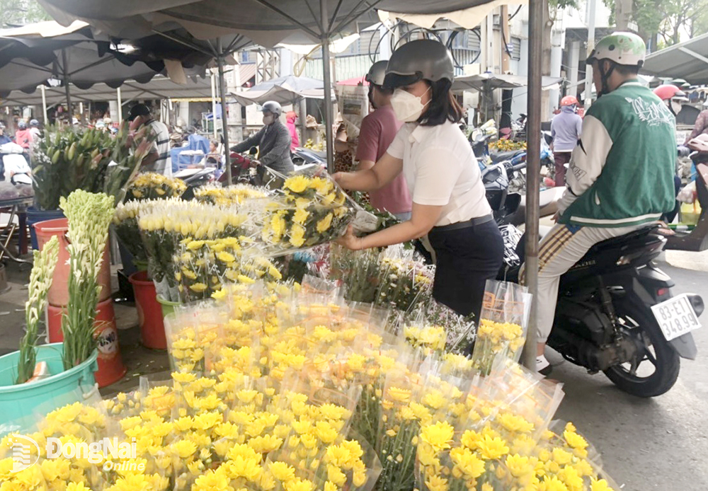 Người dân chọn mua cái loại hoa cúng dịp Tết Đoan Ngọ tại khu vực chợ Biên Hòa. 