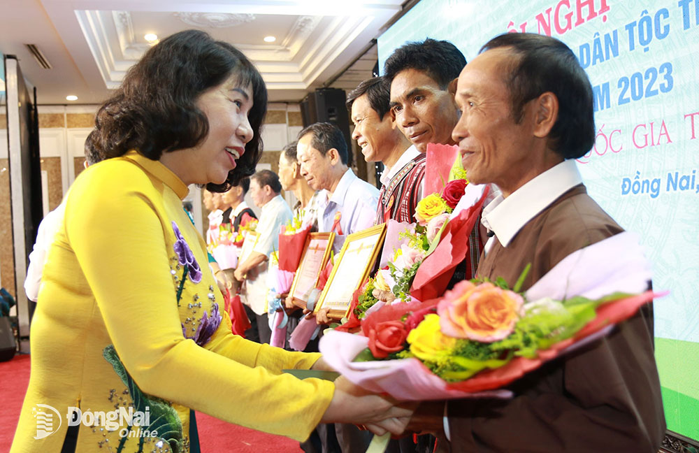 Phó chủ tịch HĐND tỉnh Hoàng Thị Bích Hằng tặng hoa chúc mừng các gia đình được tuyên dương tại hội nghị. Ảnh: Sông Thao