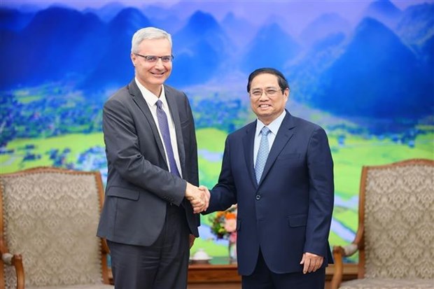 Prime Minister Pham Minh Chinh (R) and French Ambassador to Vietnam Nicolas Warnery.