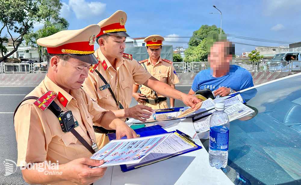 Phòng Cảnh sát giao thông Công an tỉnh lập biên bản tài xế vi phạm khi tham gia giao thông trên quốc lộ 1 (TP.Biên Hòa) Ảnh: Đăng Tùng