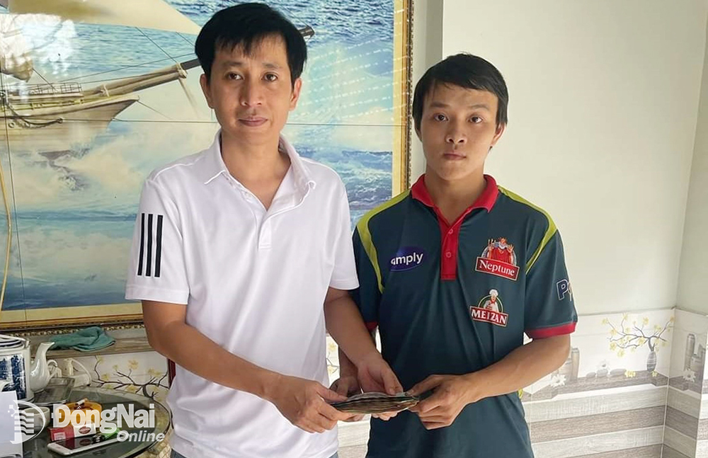 Anh Trần Quốc Huy (trái) trao lại số tiền gần 38 triệu đồng cho anh Lương Văn Hiếu